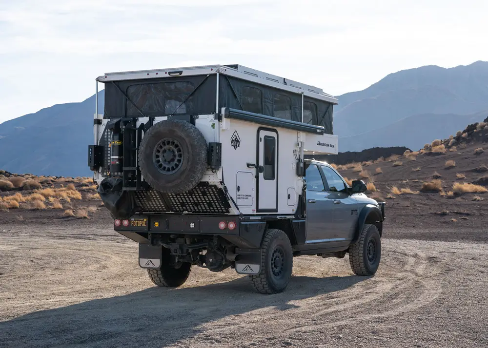 Hudson Bay 6.75’ truck camper on flatbed, three-quarter exterior view